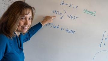 Math Professor Lisa Humphreys at white board writing equations